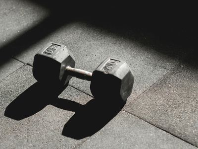 Close up of steel dumbbells on a dark gym floor