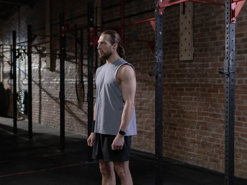 Professional male athlete training in dark industrial gym environment